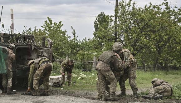 Los militares ucranianos ayudan a sus camaradas no lejos de la línea del frente en la región oriental de Ucrania de Donbas, el 21 de mayo de 2022. (Foto: AFP)