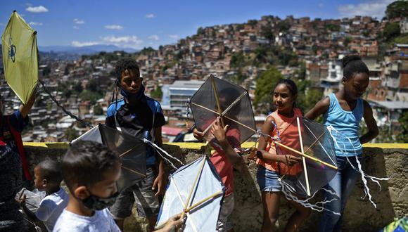 Los niños se preparan para volar cometas durante la conmemoración del 400 aniversario del barrio Petare en Caracas, el 17 de febrero de 2021. (Foto de Federico PARRA / AFP).