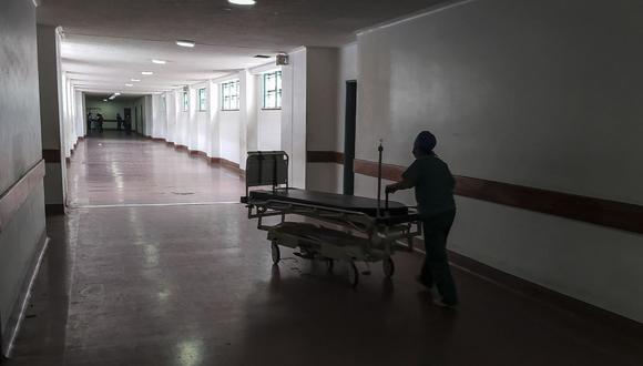 Un trabajador de la salud mueve una camilla por un pasillo del Hospital Universitario, uno de los más importantes en la formación de médicos en Venezuela. (Foto de Pedro MATTEY / AFP).