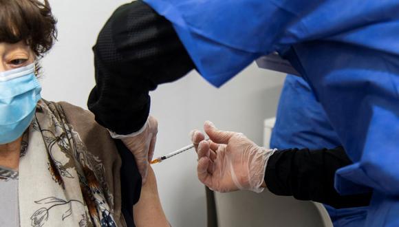Un trabajador médico administra una dosis de la vacuna contra el coronavirus Comirnaty Pfizer-BioNTech Covid-19 a una mujer en Turín, Italia, el 14 de abril de 2021. (MARCO BERTORELLO / AFP).