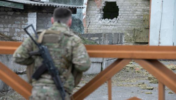 Un soldado de Ucrania mira los escombros después del bombardeo de un jardín de infantes en el asentamiento de Stanytsia Luhanska, el 17 de febrero de 2022. (Aleksey Filippov / AFP).
