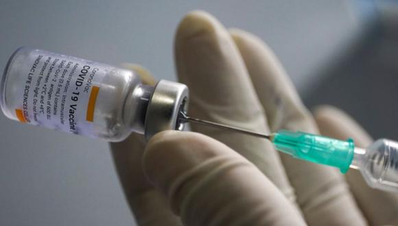 FILE PHOTO: A health worker holds a syringe and a vial of the Sinovac coronavirus disease (COVID-19) vaccine at a market after hundreds of local residents in the district tested positive for COVID-19 in Bangkok, Thailand, March 17, 2021. REUTERS/Athit Perawongmetha/File Photo