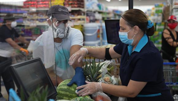 Una trabajadora de un supermercado de Estados Unidos. Muchos reciben un salario mínimo de 15 dólares la hora y continúan a pesar de lo peligroso que resulta salir de casa en estos momentos. Foto: Joe Raedle/Getty Images/AFP