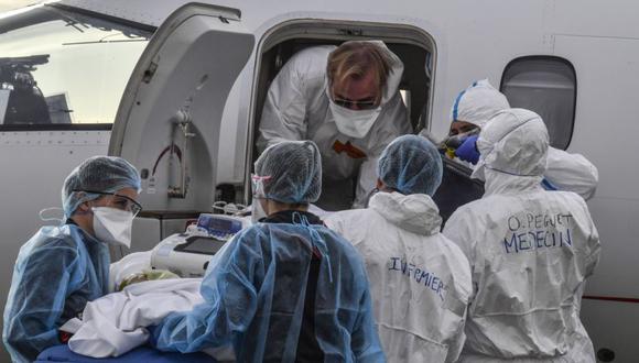 Personal médico transporta a un paciente en camilla a la espera de vuelo médico, para ser evacuado a otro hospital, en el aeropuerto de Bron cerca de Lyon, sureste de Francia en medio del brote de el Covid-19. (Foto: EFE/EPA/PHILIPPE DESMAZES).
