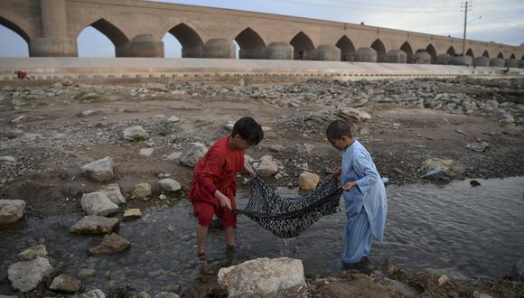 Imagen de archivo | Los niños pescan con un foulard cerca del puente Pul-e-Malan en Herat. (Foto de WAKIL KOHSAR / AFP)