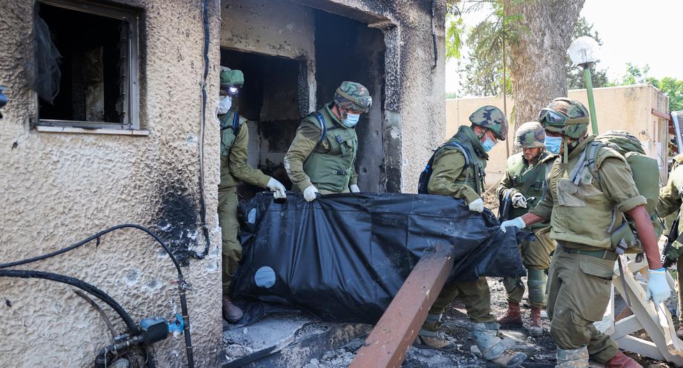 Soldados de Israel retiran el cuerpo de una persona muerta durante el ataque de Hamás en Kfar Aza, al sur del país, en la frontera con la Franja de Gaza, el 10 de octubre de 2023. (Foto de JACK GUEZ / AFP).