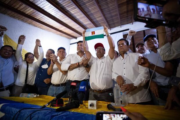 El candidato opositor a la Gobernación de Barinas -cuna de Hugo Chávez, Sergio Garrido (c), muestra la bandera del estado durante una rueda de prensa hoy, desde su comando de Campaña en Barinas (Venezuela). (Foto: EFE/ Rayner Peña R.). 
