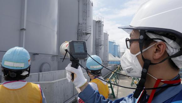 Miembro de la Compañía de Energía Eléctrica de Tokio midiendo los niveles de radiación alrededor de los tanques de almacenamiento de agua contaminada con radiación en la planta nuclear Fukushima. (Foto: AFP)