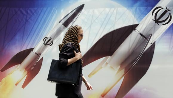 Una mujer iraní pasa junto a una pancarta antiisraelí que lleva imágenes de misiles iraníes, en Teherán, Irán, 16 de abril de 2024. (EFE/EPA/ABEDIN TAHERKENAREH).