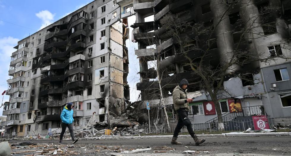 La gente pasa frente a los edificios destruidos en la ciudad de Borodianka, al noroeste de Kiev, la capital de Ucrania, el 4 de abril de 2022. (Sergei SUPINSKY / AFP).