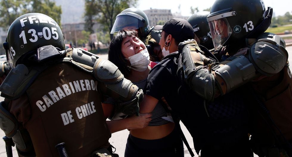 Los Carabineros detienen a una mujer en Santiago de Chile. (AFP / Pablo VERA).