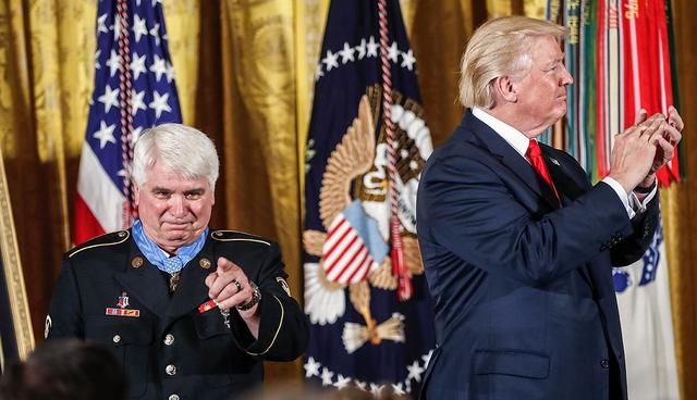 Retired Army medic James McCloughan, left, points to people in the audience after President Donald Trump bestowed the nation's highest military honor, the Medal of Honor, to McCloughan during a ceremony in the East Room of the White House in Washington, Monday, July 31, 2017. McCloughan is credited with saving the lives of members of his platoon nearly 50 years ago in the Battle of Nui Yon Hill in Vietnam. (AP Photo/Pablo Martinez Monsivais)