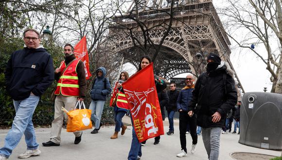 Los manifestantes sostienen banderas de los sindicatos CGT durante una huelga del personal de la Torre Eiffel, por la gestión financiera del monumento por parte de la ciudad, cerrando el monumento al público durante la segunda semana de las vacaciones escolares francesas, en París el 20 de febrero de 2024. (Foto de Geoffroy VAN DER HASSELT / AFP)