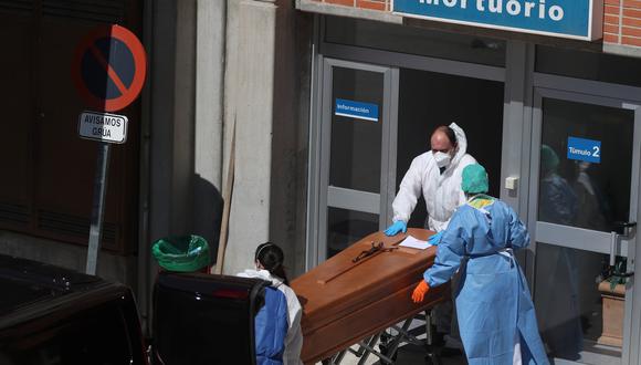 Trabajadores funerarios que usan trajes protectores sacan un ataúd de la morgue en el Hospital Severo Ochoa en Leganés, España, uno de los países más golpeados por el coronavirus. (REUTERS / Susana Vera).