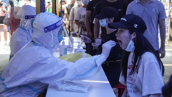 Una mujer (derecha) recibiendo una prueba de ácido nucleico para el coronavirus Covid-19 en Guangzhou, en la provincia de Guangdong, en el sur de China. (Foto: STR / AFP China OUT).