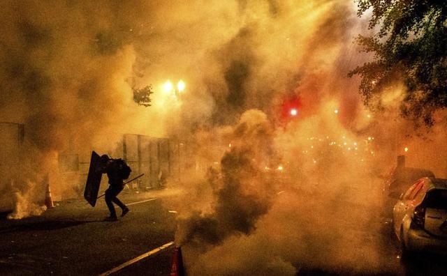 Un manifestante de Black Lives Matter usa un escudo mientras los policías federales disparan gases lacrimógenos cerca del Palacio de Justicia de Portland, Oregon. (Foto AP / Noah Berger).