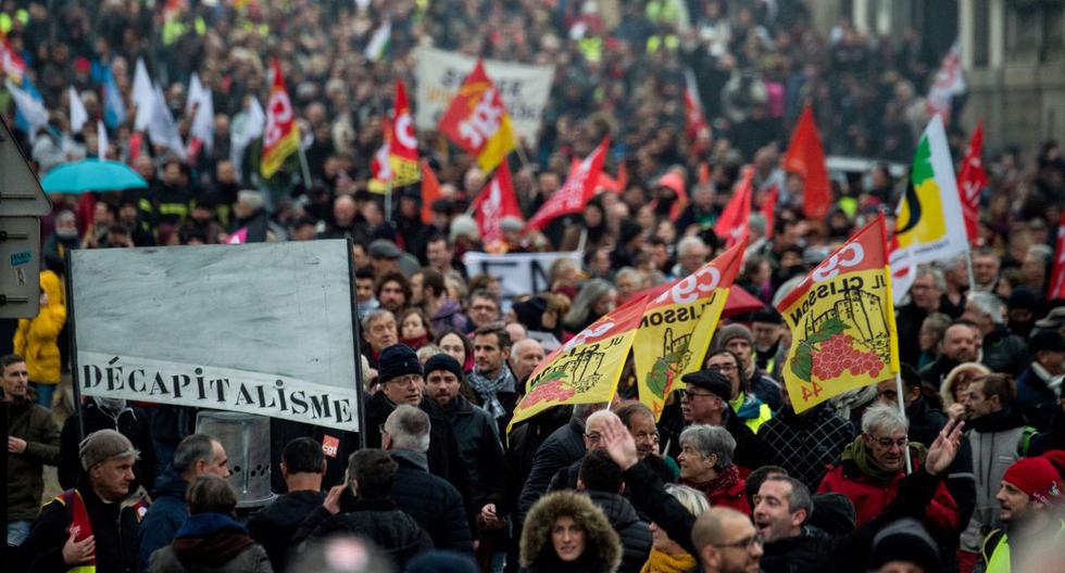 Las personas ondean banderas y sostienen carteles durante una manifestación el pasado 10 de diciembre de 2019 en Nantes. (AFP)