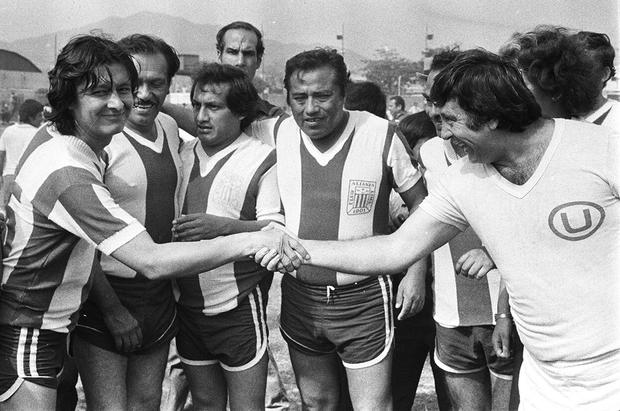Artists from the television program Risas y Salsa play a soccer match representing the Alianza Lima and Universitario clubs.  In the image, Adolfo Chuiman and Tulio Loza shake hands.  They are watched by Leonidas Carbajal (2 left), Elmer Alfaro "Machucao" (3 left) and Román Gamez "Uncle Ronco" (4 left).  Postcard of December 19, 1982. Photo: Darío Médico / GEC Historical Archive