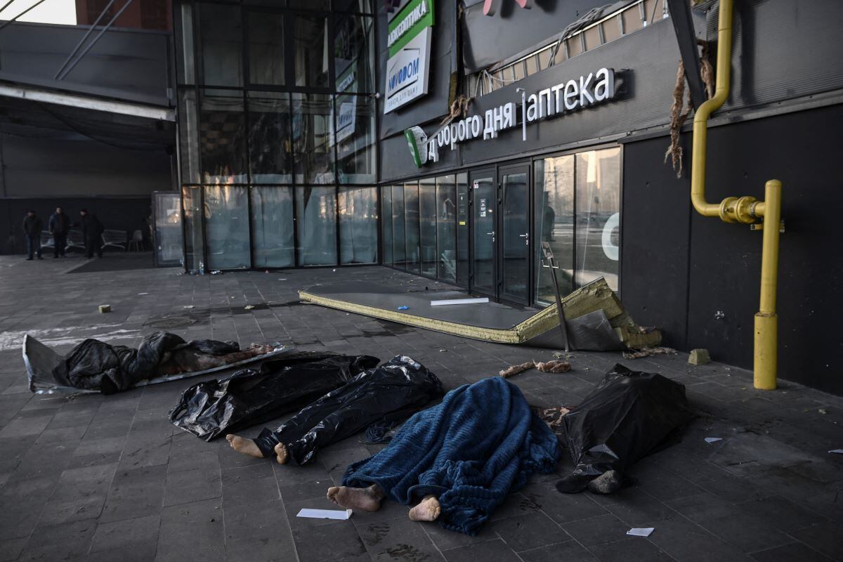 The bodies of Ukrainians covered with blankets and plastic bags outside the Retroville shopping center after a Russian missile attack in kyiv on March 21, 2022. (ARIS MESINIS / AFP)
