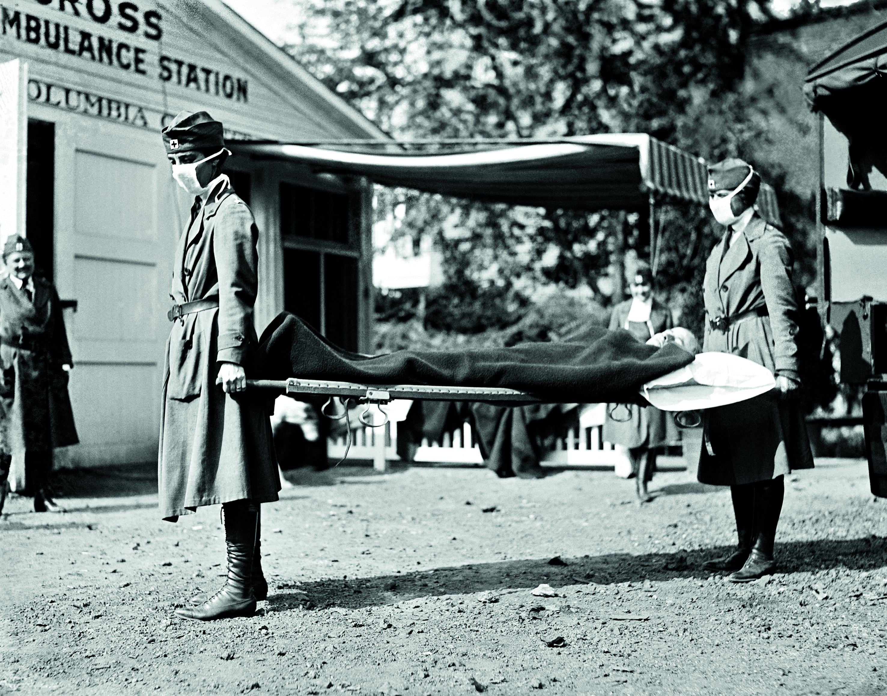 Washington D. C. Dos enfermeras de la Cruz Roja conducen a un paciente durante la pandemia de gripe en 1918, que coincidió con los días finales de la Primera Guerra Mundial. Al frente, un titular de El Comercio de enero de 1919, que llamaba a prevenir la enfermedad. FOTO: Getty Images.