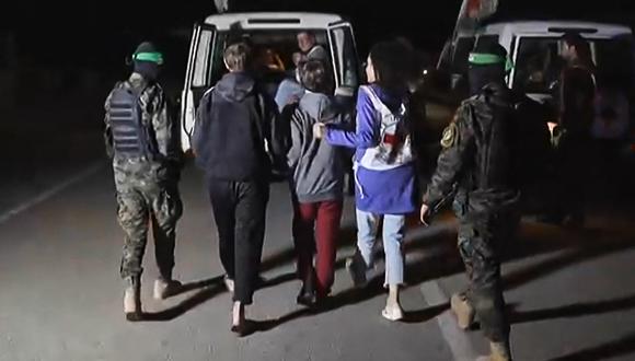 Combatientes de Hamás acompañan a rehenes israelíes recién liberados a un vehículo de la Cruz Roja en la Franja de Gaza el 27 de noviembre de 2023. (AFP).