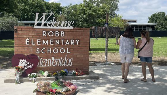 Mujeres toman fotografías a los alrededores del memorial en honor a las víctimas de la matanza en la puerta de la Escuela Primaria Robb en Uvalde, Texas, EE.UU., el 23 de mayo de 2023. (Foto de Paula Escalada Medrano / EFE)
