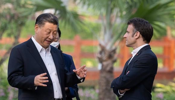 El presidente chino Xi Jinping (izquierda) y el presidente francés Emmanuel Macron (derecha) hablan mientras visitan el jardín de la residencia del gobernador de Guangdong, el 7 de abril de 2023, donde vivía el padre del presidente chino XI Jinping, XI Zhongxun. (Foto de Jacques WITT / PISCINA / AFP)