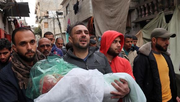 El padre de Masa Shoman lleva el cuerpo de su hija que murió durante el bombardeo israelí durante su funeral en Rafah, en el sur de la Franja de Gaza, el 17 de enero de 2024, en medio de batallas en curso entre Israel y el militante palestino. grupo Hamás. (Foto de AFP)