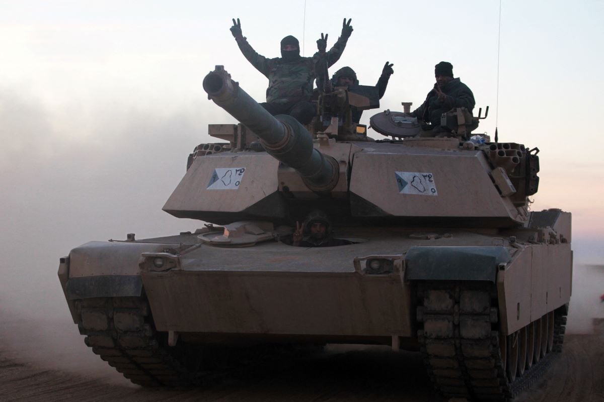 In this file photo taken on February 19, 2017, Iraqi forces display the V sign on an M1 Abrams tank as they advance near the village of Sheikh Younis, south of Mosul.  (AHMAD AL-RUBAYE / AFP).