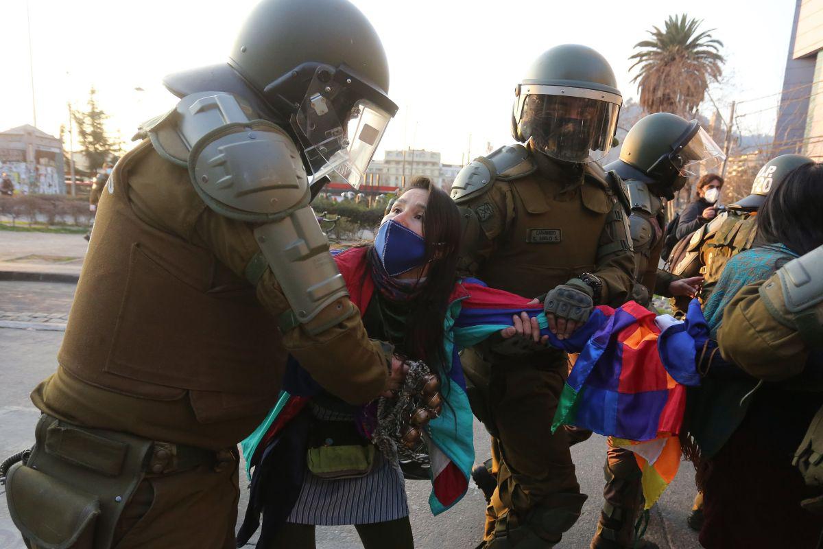 Una joven mujer es detenida por agentes policiales durante las protestas en contra del gobierno chileno y a favor del pueblo Mapuche. (EFE/Elvis González).