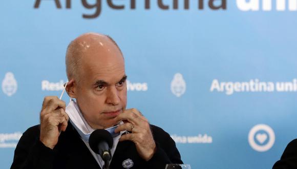 El Jefe de Gobierno de la Ciudad Autónoma de Buenos Aires, Horacio Rodríguez Larreta, se quita la mascarilla antes del inicio de una rueda de prensa en Olivos, al norte de Buenos Aires, el 23 de mayo de 2020. (Alejandro PAGNI / AFP).