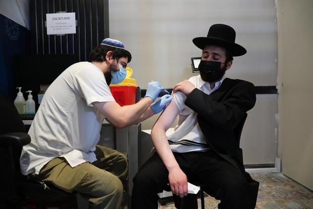 A male nurse injects an ultra-Orthodox Jew with a third dose of the COVID-19 coronavirus vaccine in Jerusalem, Israel.  (EFE / OPEN SULTAN).