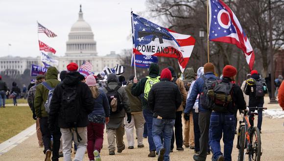 En esta fotografía de archivo del miércoles 6 de enero de 2021, partidarios del presidente Donald Trump marchan hacia el Capitolio sosteniendo banderas durante una manifestación en Washington.  (Foto AP / Carolyn Kaster, archivo)