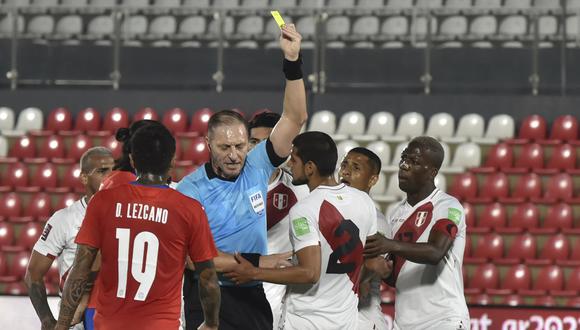 Néstor Pitana le saca la tarjeta amarilla a Carlos Zambrano durante el Perú vs. Paraguay. (Foto: AFP)