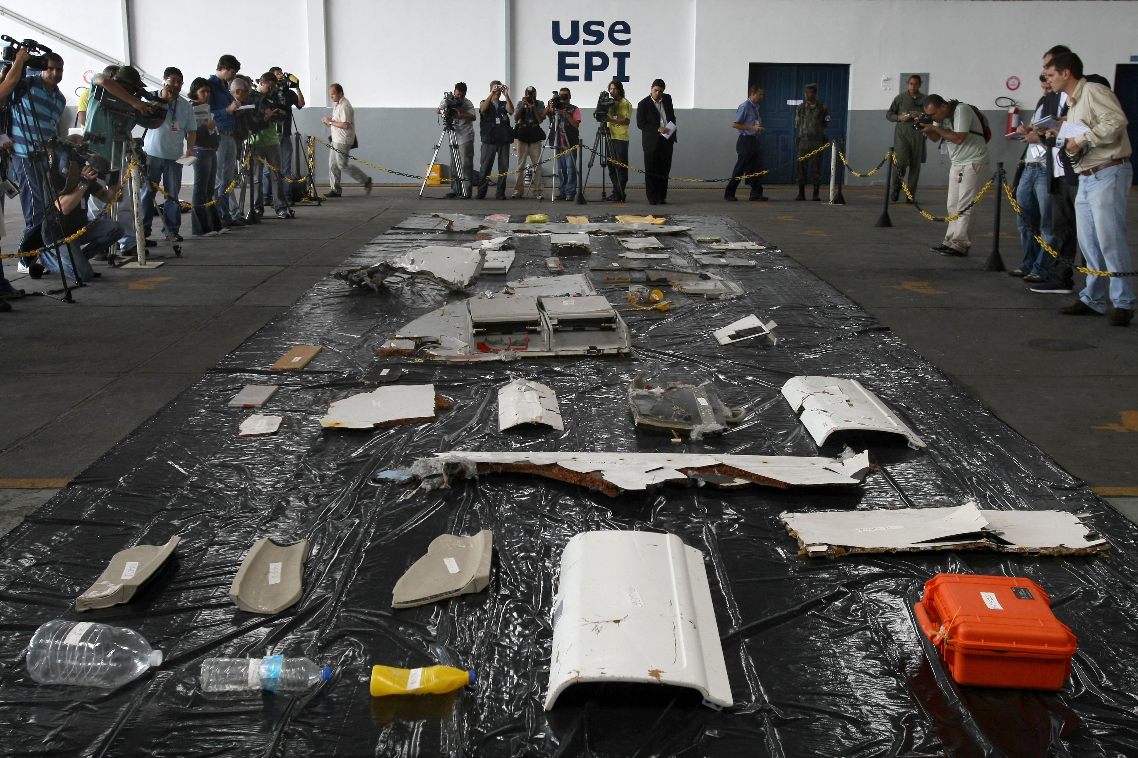 Journalists report on the first wreckage and objects of the Air France A330 plane, flight AF447, lost mid-flight over the Jene 1st Atlantic Ocean and recovered from the sea, at the hangar of the airbase, in Recife, northeastern Brazil, on 12 June 2009. Whether or not the black boxes from Air France Flight 447 have been found, the crash has shown that new technology is needed to record the last moments of a flight in real time, an aviation expert argues.  AFP PHOTO/Mauricio LIMA (Photo by MAURICIO LIMA / AFP)