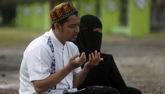 Habitantes de Aceh rezan y leen el Sagrado Corán en una fosa común para las víctimas durante la Conmemoración del Tsunami de 2004 en Banda Aceh, Indonesia, el 26 de diciembre de 2022. (Foto de EFE/EPA/HOTLI SIMANJUNTAK)