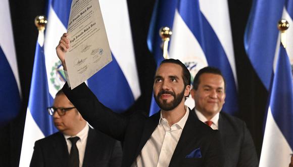 El presidente salvadoreño Nayib Bukele muestra la certificación que lo acredita como presidente electo de El Salvador para el periodo 2024-2029 en el Teatro Nacional de San Salvador el 29 de febrero de 2024. (Foto de Marvin RECINOS / AFP)