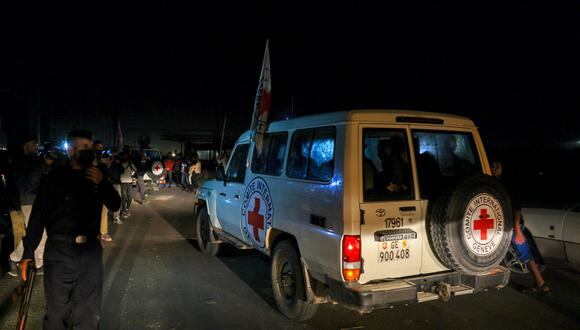 Según se informa, vehículos de la Cruz Roja Internacional que transportaban a rehenes israelíes liberados por Hamás cruzan el punto fronterizo de Rafah en la Franja de Gaza de camino a Egipto, desde donde serían trasladados en avión a Israel para reunirse con sus familias, el 24 de noviembre de 2023. (Foto de Mohammed ABED / AFP)