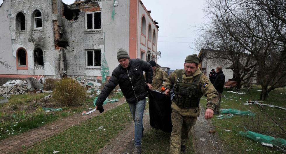 Los rescatistas llevan un cuerpo en el pueblo de Andriivka, región de Kiev, el 10 de abril de 2022. (Sergei CHUZAVKOV / AFP).