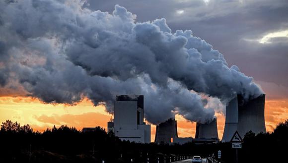 Un grupo de chimeneas emitiendo gases contaminantes a la atmósfera. (Foto referencial de Filip Singer / EFE)