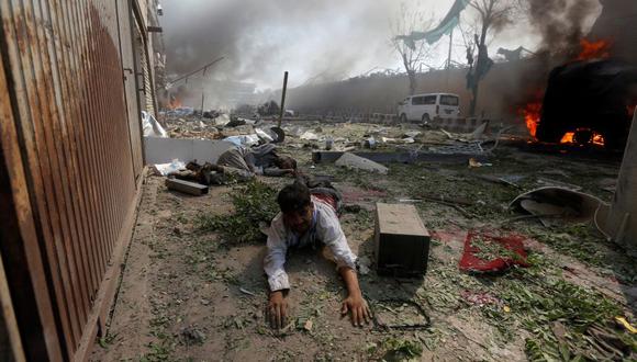 Un sobreviviente se arrastra luego del estallido de un camión bomba en el barrio diplomático de Kabul. (Reuters).