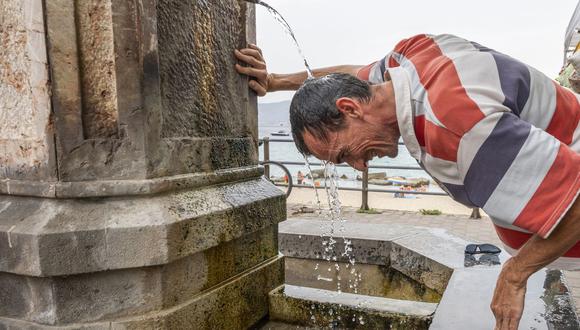 Un hombre se refresca en una fuente durante un caluroso día de verano en Messina, Italia, el 11 de agosto de 2021. (Foto de Giovanni ISOLINO / AFP).