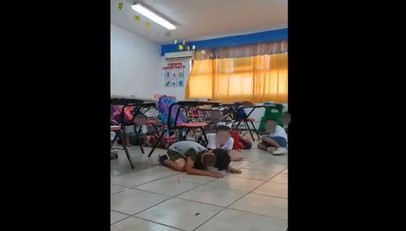 Una profesora de primaria intenta tranquilizar a los menores durante el enfrentamiento en Empalme, Sonora.