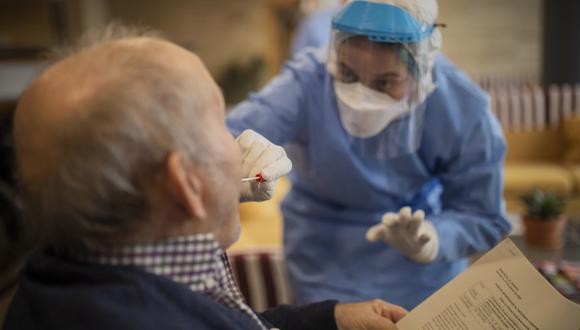 Una enfermera realiza pruebas de detección de coronavirus a un anciano en Barcelona, ​​España. (AP Photo / Santi Palacios).