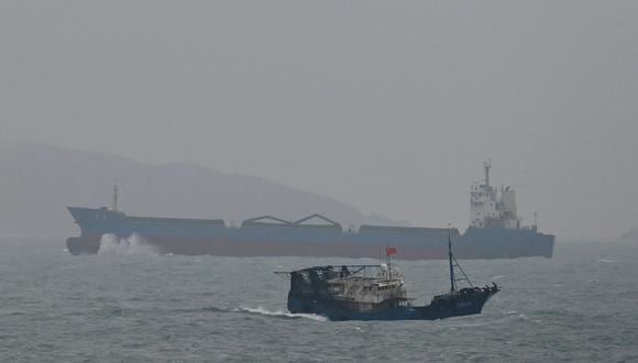 Un buque de carga pasa por una isla vista desde la isla de Pingtan, el punto más cercano a Taiwán, en la provincia de Fujian, sureste de China, el 6 de abril de 2023. (Foto de GREG BAKER / AFP)