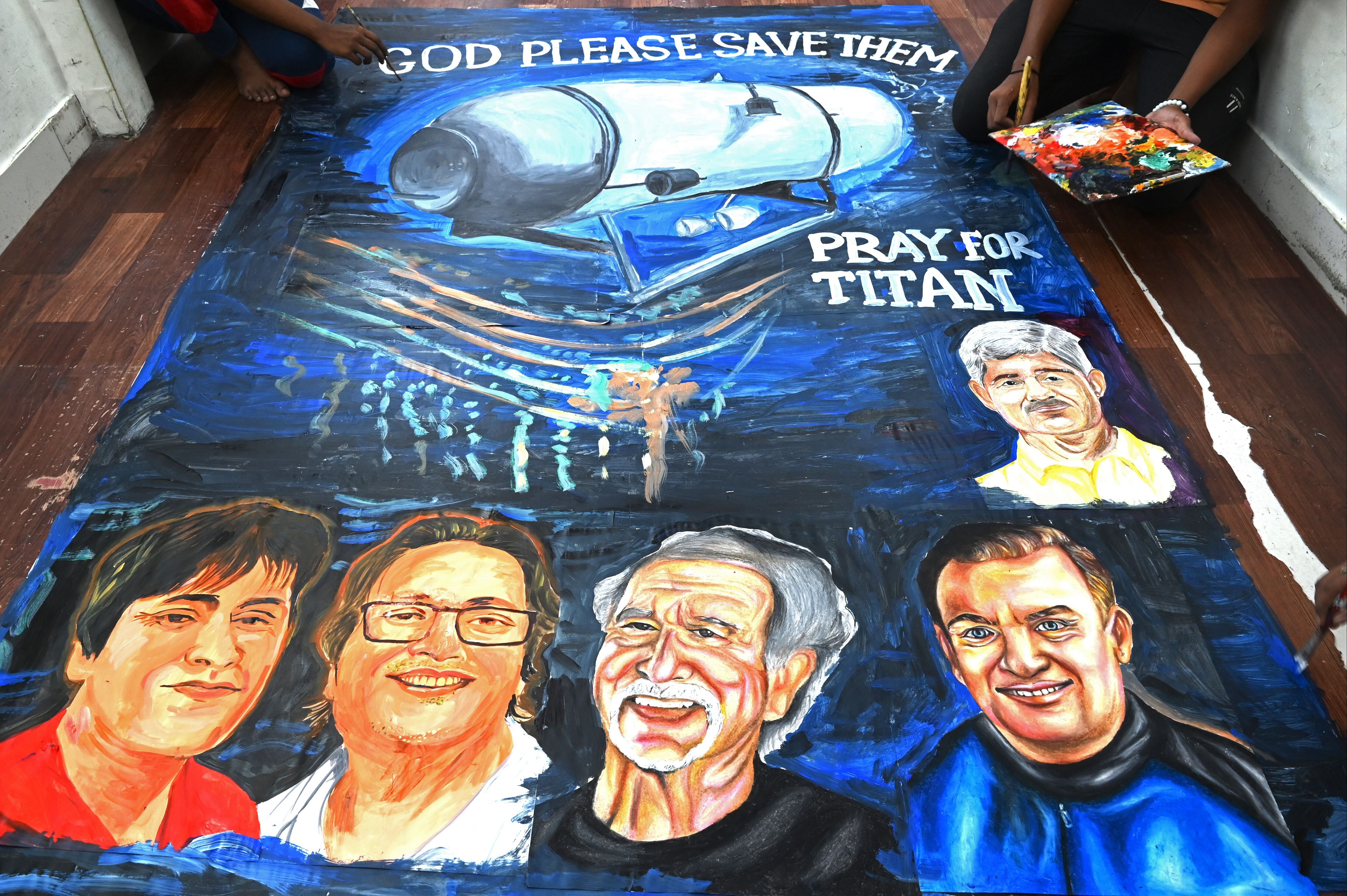 Students at an Indian art school put the finishing touches on a painting depicting five people who died aboard the Titan submersible.  (Photo by INDRANIL MUKHERJEE / AFP).