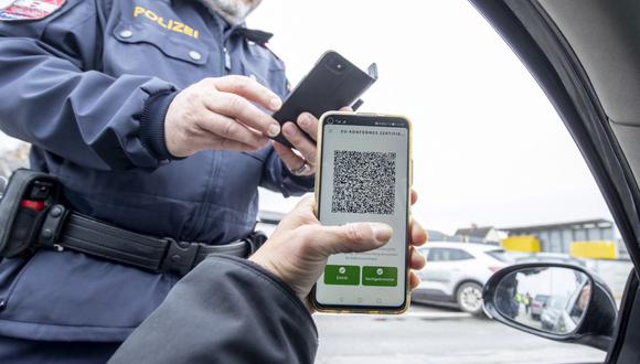 Un policía verifica el certificado de vacunación digital contra el coronavirus de un conductor durante un control de tráfico en Graz, Austria, el 15 de noviembre de 2021. (ERWIN SCHERIAU / APA / AFP).