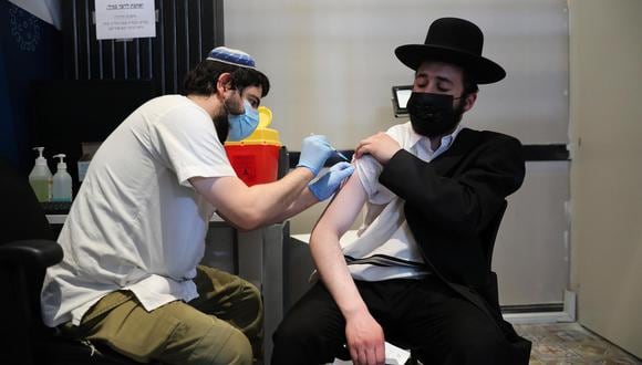 Un enfermero inyecta a un judío ultraortodoxo una tercera dosis de la vacuna contra el coronavirus COVID-19 en Jerusalén, Israel. (EFE/ABIR SULTAN).