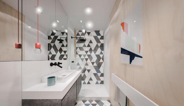 Este baño presenta un look original gracias a que el muro de la ducha está revestido con mosaicos hidráulicos. Los espejos de pared a pared permiten crear profundidad. (Foto: Matuszek Architects)