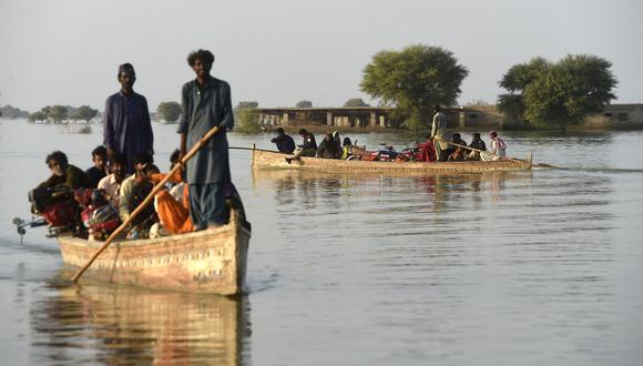 Los desplazados internos usan botes para cruzar un área inundada en Dadu, en la provincia de Sindh, el 27 de octubre de 2022. (Foto de Asif HASSAN / AFP)